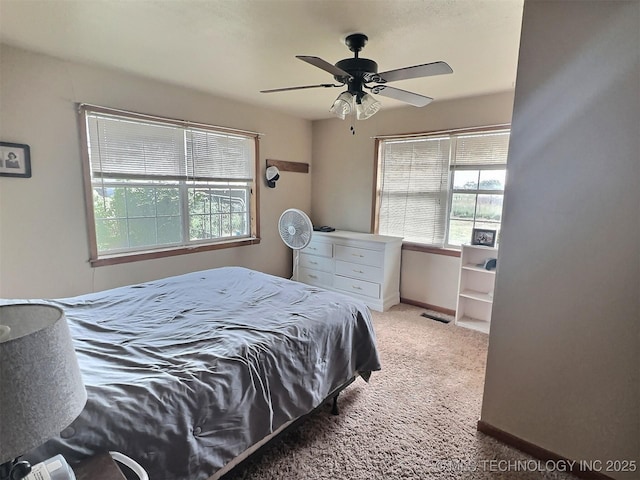 bedroom with ceiling fan, visible vents, baseboards, and light colored carpet