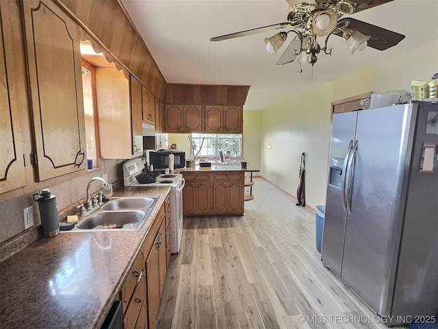 kitchen featuring light wood-style flooring, white electric range, a peninsula, a sink, and stainless steel refrigerator with ice dispenser