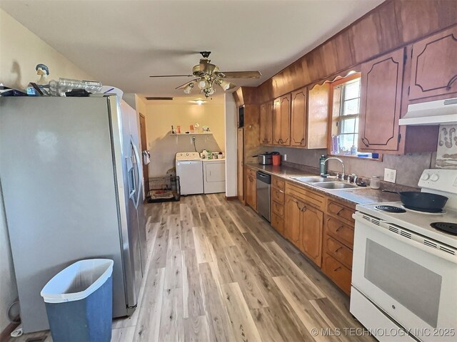 kitchen with light wood-style flooring, appliances with stainless steel finishes, a sink, separate washer and dryer, and under cabinet range hood