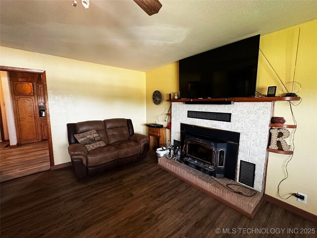 living area with visible vents, a textured ceiling, baseboards, and wood finished floors