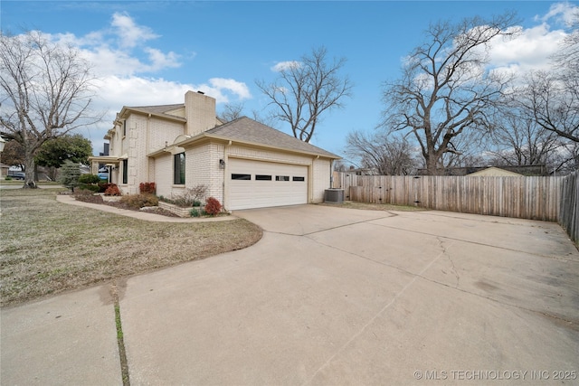 view of property exterior with concrete driveway, brick siding, fence, and a chimney