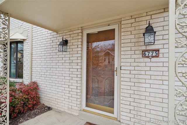 entrance to property featuring brick siding