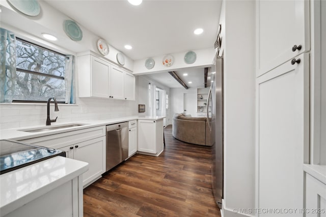 kitchen featuring appliances with stainless steel finishes, dark wood finished floors, a wealth of natural light, and a sink