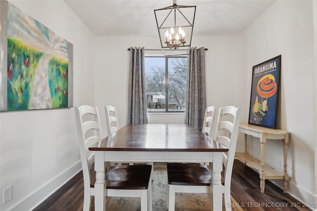 dining space featuring baseboards, dark wood finished floors, and an inviting chandelier