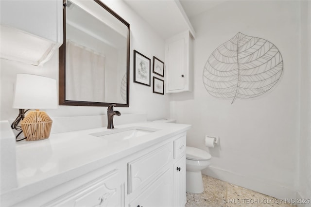 bathroom with baseboards, vanity, and toilet