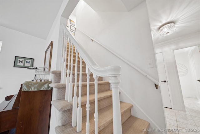 stairs featuring baseboards and tile patterned floors