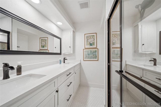 bathroom with double vanity, a sink, and visible vents