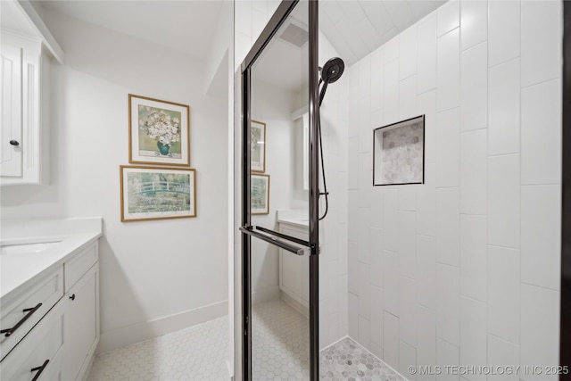 bathroom featuring a shower stall, vanity, and baseboards