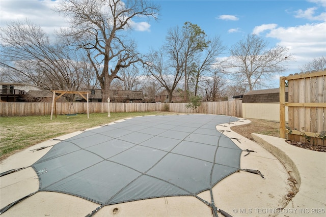 view of swimming pool with a fenced backyard and a lawn