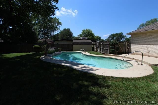 pool featuring a yard, a patio, a storage shed, a fenced backyard, and an outdoor structure