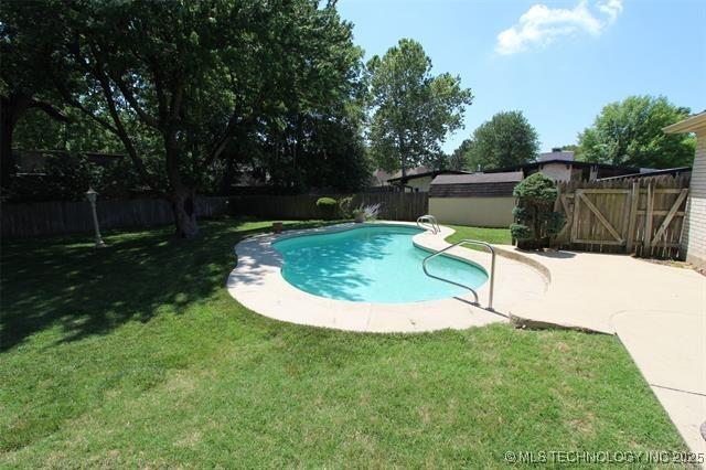 view of pool with a yard, a patio area, a fenced backyard, and a fenced in pool