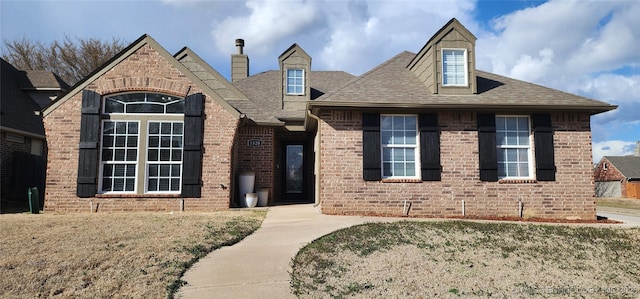 view of front of house featuring brick siding and a shingled roof