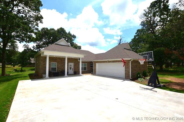 view of front of house featuring a garage, a front lawn, concrete driveway, and brick siding