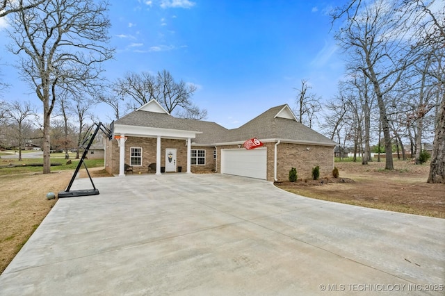 view of front of property featuring a shingled roof, brick siding, driveway, and an attached garage