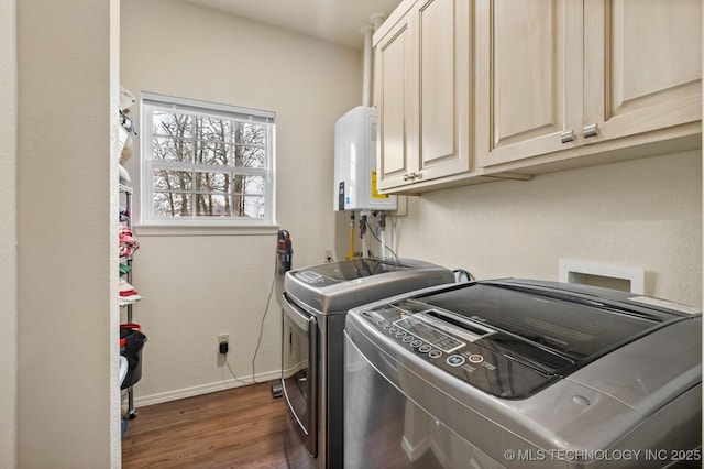 washroom featuring cabinet space, baseboards, dark wood finished floors, washer and dryer, and water heater