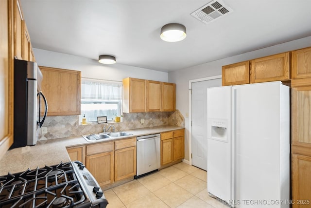 kitchen featuring visible vents, a sink, stainless steel appliances, light countertops, and decorative backsplash