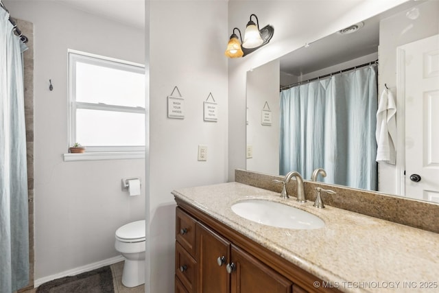 full bath with toilet, vanity, and baseboards