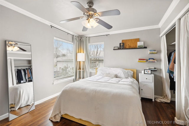 bedroom featuring a closet, crown molding, baseboards, and wood finished floors