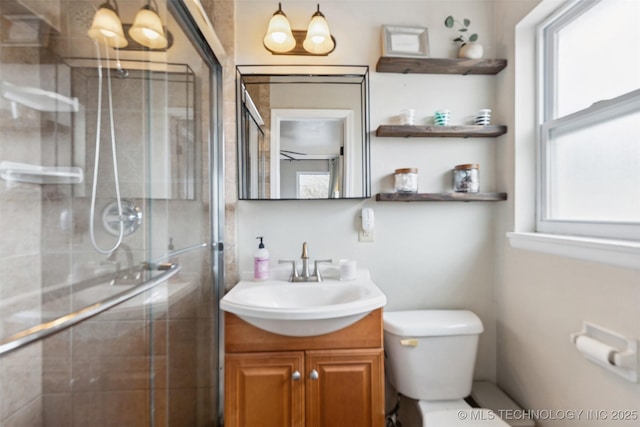 bathroom featuring vanity, toilet, a healthy amount of sunlight, and a stall shower