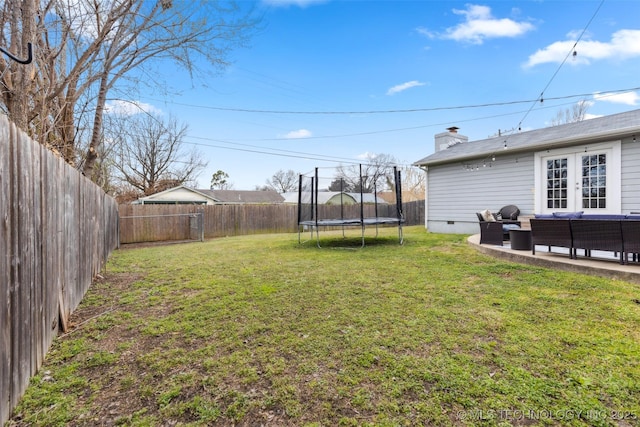 view of yard with a fenced backyard, a patio area, an outdoor living space, and a trampoline