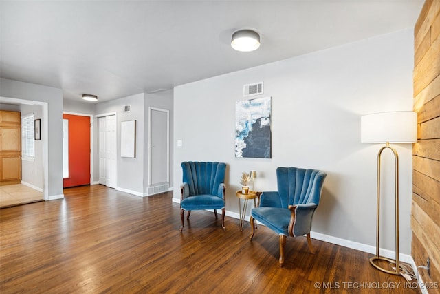 living area featuring visible vents, baseboards, and wood finished floors