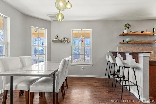 dining room with visible vents, dark wood-type flooring, and baseboards