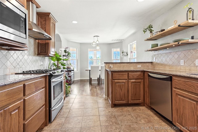 kitchen with light stone counters, light tile patterned floors, open shelves, appliances with stainless steel finishes, and brown cabinets