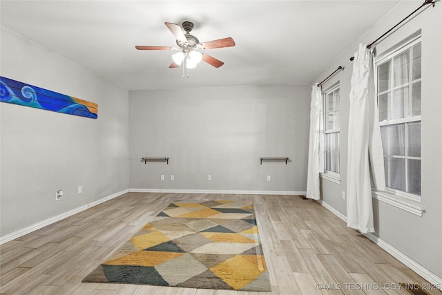 unfurnished room featuring ceiling fan, baseboards, and wood finished floors