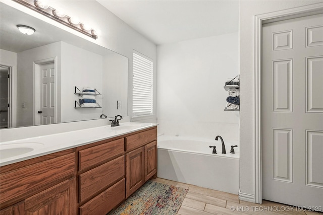 bathroom featuring a garden tub, double vanity, and a sink