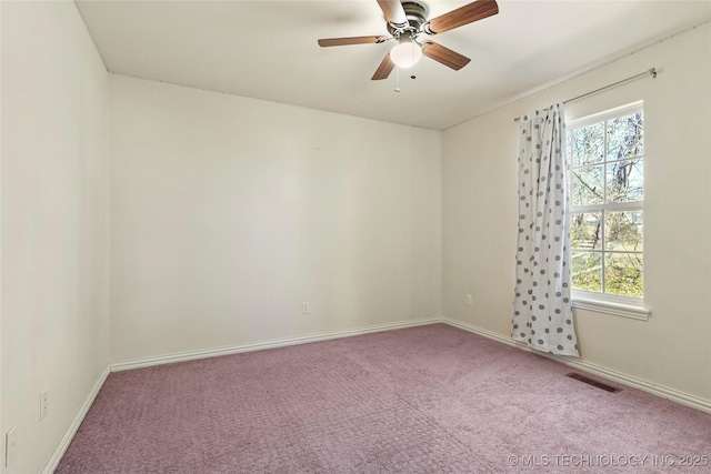 carpeted empty room featuring visible vents, plenty of natural light, baseboards, and a ceiling fan