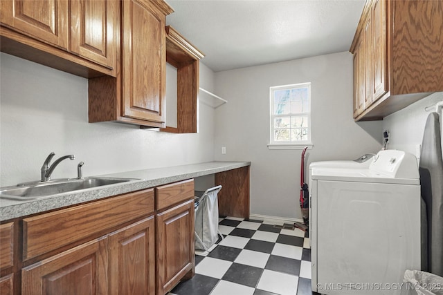 washroom with washing machine and clothes dryer, a sink, cabinet space, and dark floors