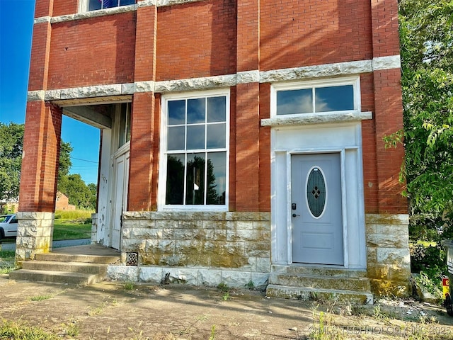 property entrance featuring stone siding and brick siding