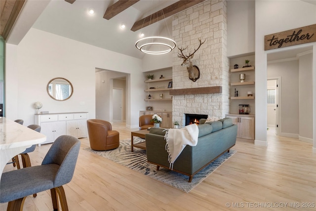 living room with light wood-style floors, a fireplace, high vaulted ceiling, and beamed ceiling