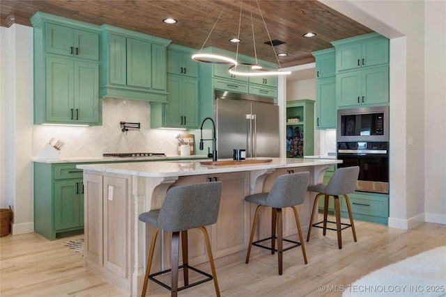 kitchen featuring tasteful backsplash, visible vents, light wood-style flooring, built in appliances, and light countertops