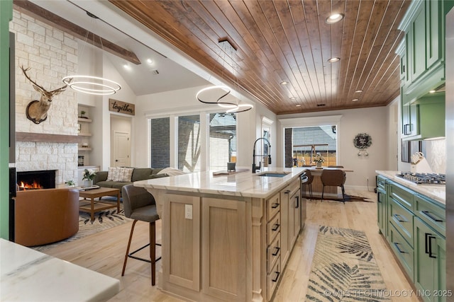 kitchen with a center island with sink, light wood-style floors, a sink, wooden ceiling, and green cabinetry