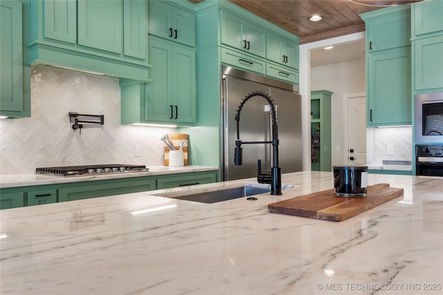 kitchen featuring green cabinetry, appliances with stainless steel finishes, wooden ceiling, and light stone countertops