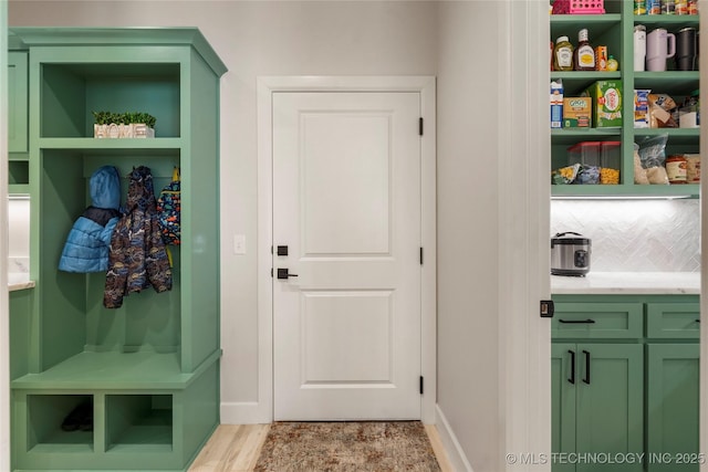 mudroom with light wood finished floors and baseboards