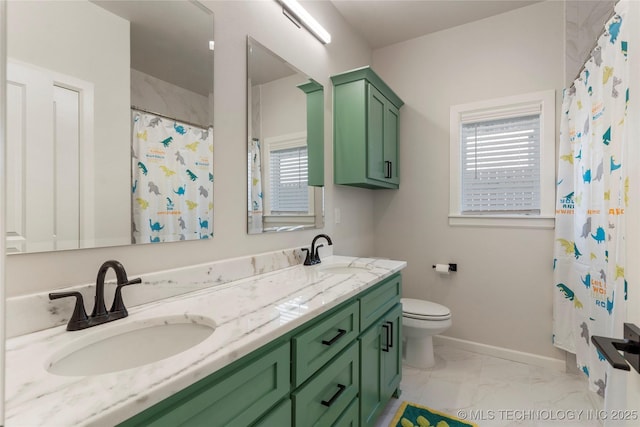 bathroom with double vanity, baseboards, toilet, marble finish floor, and a sink