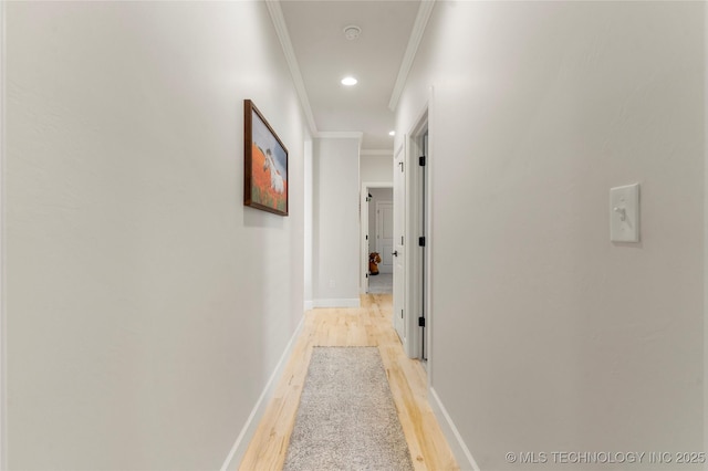 corridor featuring ornamental molding, recessed lighting, light wood-style flooring, and baseboards