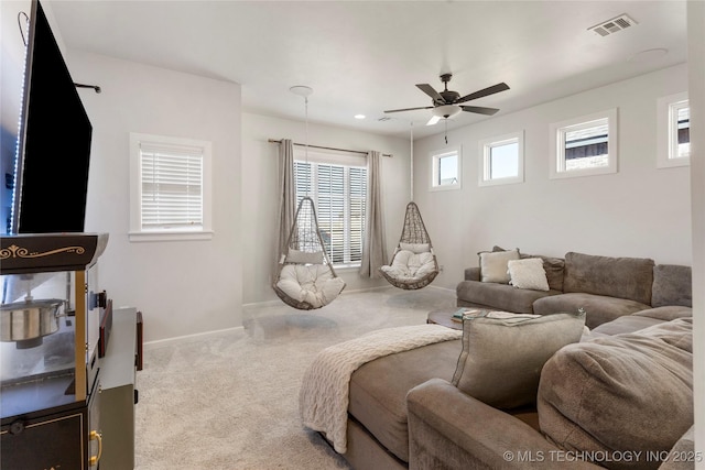 living area with carpet, visible vents, baseboards, and a ceiling fan