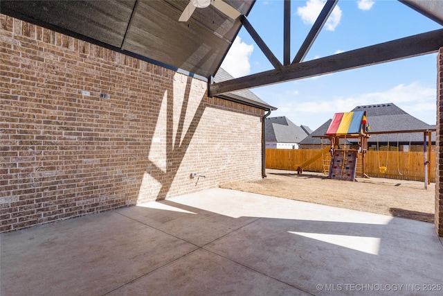 view of patio / terrace featuring a ceiling fan, fence, and a playground