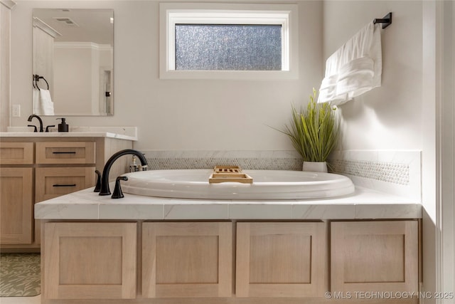 full bathroom featuring a garden tub, visible vents, and vanity