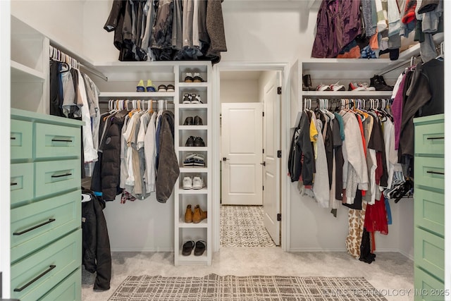 walk in closet featuring light carpet