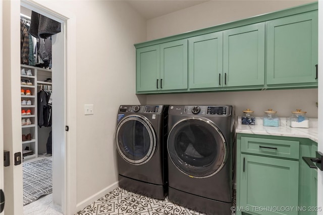 washroom featuring washer and dryer, cabinet space, baseboards, and light tile patterned floors