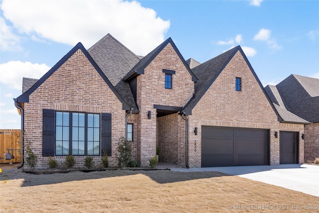 view of front of home featuring a shingled roof, concrete driveway, an attached garage, a front lawn, and brick siding