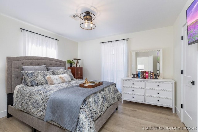 bedroom with visible vents and light wood-style flooring