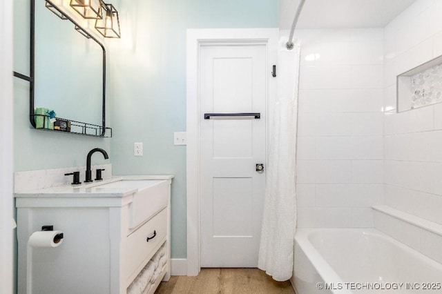 full bathroom with shower / bath combo, vanity, and wood finished floors