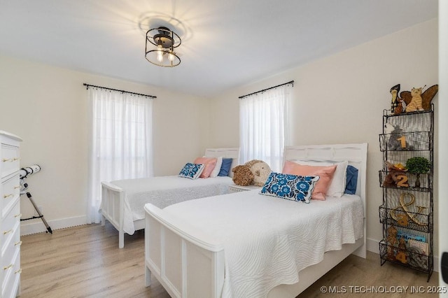 bedroom featuring light wood-style flooring and baseboards