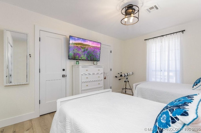 bedroom with light wood-style floors, baseboards, and visible vents