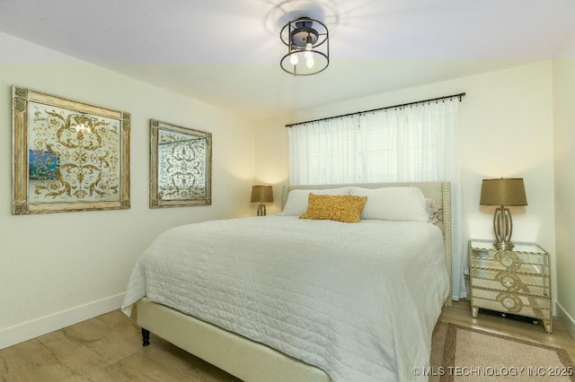 bedroom with baseboards and wood finished floors